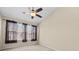 Cozy bedroom with a ceiling fan and a window with curtains for natural light at 8307 Fontera Dr, Davenport, FL 33896