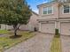 Tan two-story townhome with two-car garage and brick paver driveway at 8307 Fontera Dr, Davenport, FL 33896