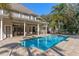 Spacious backyard featuring a refreshing pool, covered patio, and meticulously designed landscaping at 9501 Hempel Cove Blvd, Windermere, FL 34786