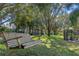 Wooden backyard swing hanging from a mature oak tree in a grassy backyard at 9501 Hempel Cove Blvd, Windermere, FL 34786
