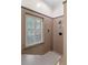 This bathroom boasts a convenient shower seat and window with plantation shutters, perfect for relaxation and natural light at 9501 Hempel Cove Blvd, Windermere, FL 34786