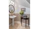 Charming powder room featuring a pedestal sink, decorative mirror, wainscoting, and tasteful décor at 9501 Hempel Cove Blvd, Windermere, FL 34786