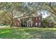 Charming two-story red brick home with a well-manicured lawn and mature trees at 9501 Hempel Cove Blvd, Windermere, FL 34786