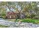 Charming two-story red brick home with a well-manicured lawn and mature trees at 9501 Hempel Cove Blvd, Windermere, FL 34786