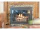 Close-up of a stone fireplace with a glass door, a decorative wood frame and rustic details at 9501 Hempel Cove Blvd, Windermere, FL 34786
