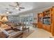 Spacious living room features a leather sofa, ceiling fans, and french doors leading to the pool at 9501 Hempel Cove Blvd, Windermere, FL 34786