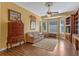 Comfortable living room featuring warm yellow walls, hardwood floors, a ceiling fan, and a bay window for ample natural light at 9501 Hempel Cove Blvd, Windermere, FL 34786