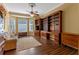 This living room features hardwood floors, a ceiling fan, and a large bookshelf, creating a cozy and organized space at 9501 Hempel Cove Blvd, Windermere, FL 34786