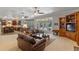 Open living room with a leather sofa and view into the kitchen and outside with stained glass windows at 9501 Hempel Cove Blvd, Windermere, FL 34786