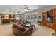 Open-concept living room with a large sofa, bookshelves, and views of the pool at 9501 Hempel Cove Blvd, Windermere, FL 34786