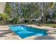 Refreshing pool is surrounded by a brick paver patio, chairs, and a wrought iron fence, creating a private backyard oasis at 9501 Hempel Cove Blvd, Windermere, FL 34786