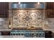 Close up of a stainless steel range with a decorative tile backsplash at 9501 Hempel Cove Blvd, Windermere, FL 34786