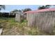 Partially fenced backyard with a gate and overgrown grass at 990 Liskeard Ave, Orange City, FL 32763