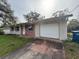 Brick and stucco home with a white garage door and grassy yard at 990 Liskeard Ave, Orange City, FL 32763