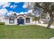 White house with blue door, landscaping, and driveway at 245 Heronwood Cir, Deltona, FL 32725