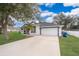 White house with blue door, landscaping, and driveway at 245 Heronwood Cir, Deltona, FL 32725