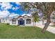 White house with blue door, landscaping, and driveway at 245 Heronwood Cir, Deltona, FL 32725