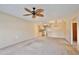 Living room with ceiling fan, carpet, and view into kitchen at 12340 Tavares Ridge Ln # 111, Tavares, FL 32778