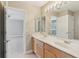 Double vanity bathroom with large mirror and access to bedroom at 1395 Legendary Blvd, Clermont, FL 34711