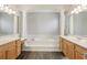 Large bathroom with double vanities, soaking tub, and columns at 1395 Legendary Blvd, Clermont, FL 34711