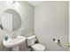 Small bathroom with pedestal sink, toilet, and round mirror at 1395 Legendary Blvd, Clermont, FL 34711