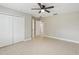 Bedroom with ceiling fan, double doors and access to bathroom at 1395 Legendary Blvd, Clermont, FL 34711