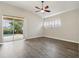 Main bedroom with hardwood floors, ceiling fan, and sliding door to patio at 1395 Legendary Blvd, Clermont, FL 34711