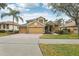 Two-story house with a three-car garage and brick driveway at 1395 Legendary Blvd, Clermont, FL 34711