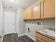 Laundry room with wooden cabinets, sink, and vinyl flooring at 1395 Legendary Blvd, Clermont, FL 34711