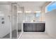 Modern bathroom showcasing a glass-enclosed shower and a double vanity with gray cabinets at 14789 Milfoil Ave, Orlando, FL 32827