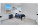 Charming bedroom with large windows, soft carpet, and a bed with dark navy comforter at 14789 Milfoil Ave, Orlando, FL 32827