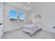 Bright bedroom featuring two windows, soft carpet, and a cozy bed with lilac blanket at 14789 Milfoil Ave, Orlando, FL 32827