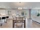 Open-concept dining and living area with hardwood floors, a modern chandelier, and sliding glass doors at 14789 Milfoil Ave, Orlando, FL 32827
