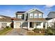 Two-story house featuring gray siding, solar panels, and a two-car garage at 14789 Milfoil Ave, Orlando, FL 32827