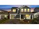 Two-story house with illuminated windows and a two-car garage at dusk at 14789 Milfoil Ave, Orlando, FL 32827