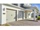 Close up of attached two car garage featuring brick paver driveway, convenient and stylish home parking at 14789 Milfoil Ave, Orlando, FL 32827