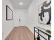 Clean, bright hallway with wood floors, neutral walls, and modern decor with art on the walls at 14789 Milfoil Ave, Orlando, FL 32827