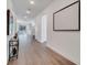 Hallway leading to the open-concept living area, featuring sleek flooring and minimalist wall art at 14789 Milfoil Ave, Orlando, FL 32827