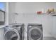 Bright laundry room, featuring washer and dryer, and ample shelving at 14789 Milfoil Ave, Orlando, FL 32827