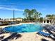 Community pool area featuring lounge chairs, palm trees, and a clubhouse in a landscaped setting at 1604 Scarlet Oak Loop # B, Winter Garden, FL 34787