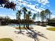 View of the community pool area with lounge chairs and a covered seating area with palm trees at 1604 Scarlet Oak Loop # B, Winter Garden, FL 34787