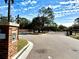 Community gated entrance featuring brick pillars, security cameras and well-maintained landscaping at 1604 Scarlet Oak Loop # B, Winter Garden, FL 34787