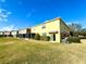 Townhouse exterior showcasing a yellow building, green lawn and screened patio at 1604 Scarlet Oak Loop # B, Winter Garden, FL 34787