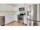 Bright kitchen featuring white cabinets, stainless steel appliances, and tile flooring at 1604 Scarlet Oak Loop # B, Winter Garden, FL 34787