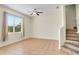 Open-plan living room with large window, ceiling fan, and staircase at 1604 Scarlet Oak Loop # B, Winter Garden, FL 34787