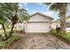 Front view of a single story house with a white garage door and palm trees at 212 Rialto Rd, Kissimmee, FL 34759