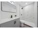 Modern bathroom boasts marble-look tile, gray vanity, black hardware, and a sleek, frameless mirror at 2235 Ginger Way, Lakeland, FL 33801