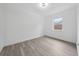 Bright, minimalist bedroom with wood-look floors, a window for natural light, and neutral walls at 2235 Ginger Way, Lakeland, FL 33801