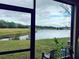 View of a lake and grassy field from a screened enclosure at 2545 Old Kent Cir, Kissimmee, FL 34758