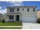 Two-story house with a neutral color scheme, a two-car garage, and a well-maintained lawn at 2912 Moulin Rd, Davenport, FL 33837